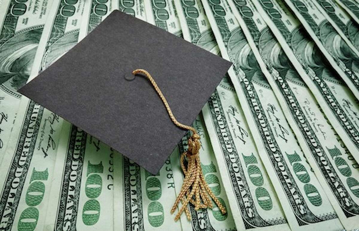 graduation cap on assorted hundred dollar bills - education concept