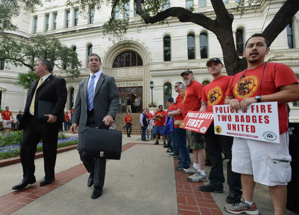 Councilman Ron Nirenberg walks by police and firefighters union members gathered in force as City Council prepares to hear the recommendations of a task force considering their retirement and health benefits on Wednesday, Feb. 19, 2014.