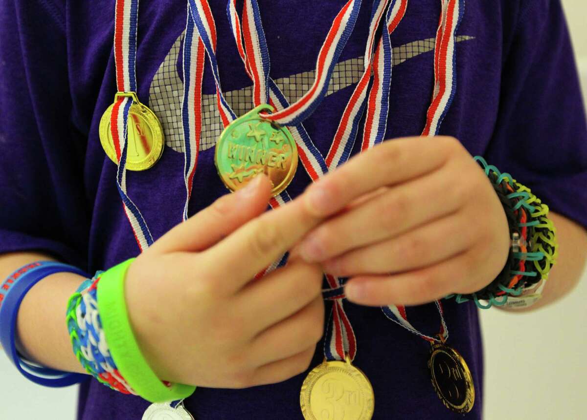 Five year-old George Gring shows off all the medals he has won during the Texas Children's Hospital Winter Olympics, Wednesday February 19, 2014 in Houston, Texas. Texas Children's Hospital will hold their own Olympic games until February 21 giving their patients the opportunity to participate in new events for a chance to compete for the gold, silver and bronze Olympic medals.