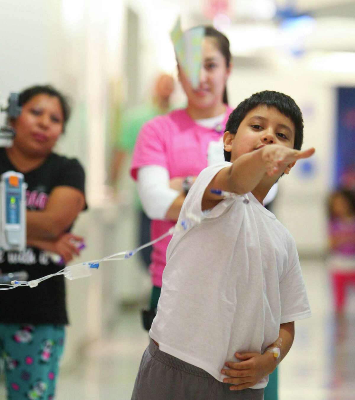Eight year-old Leonardo Sandoval sees how long his paper plane can fly during the paper airplane challenge event in Texas Children's Hospital Winter Olympics.