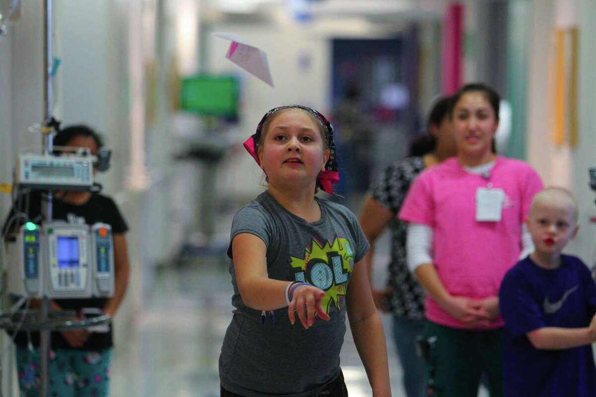 Ten year-old Emily Marroquin shows how far she can throw her paper airplane during the paper airplane challenge event in the first ever Texas Children's Hospital Winter Olympics.