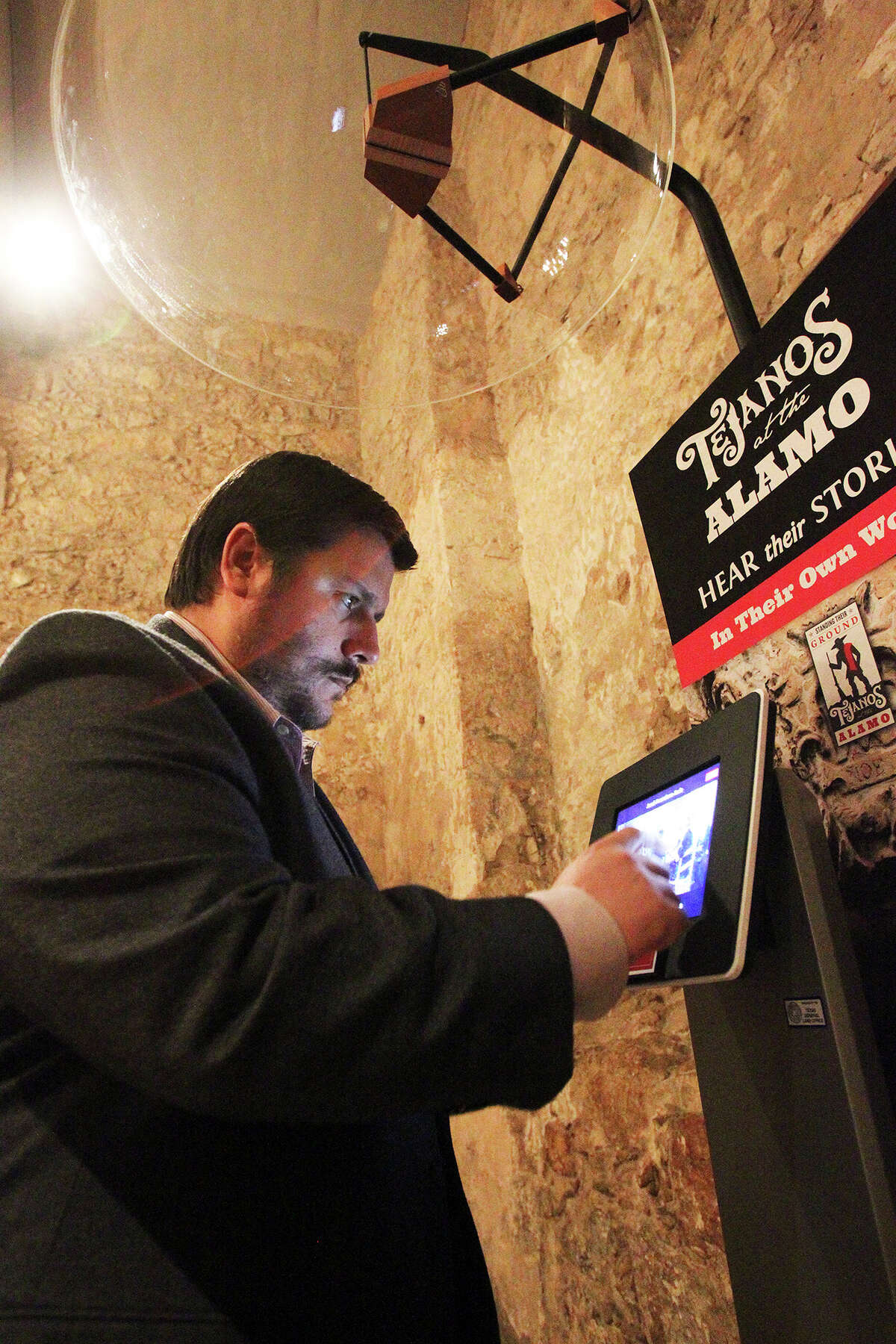Dr. Jose Barragan demonstrates an audio information station where visitors will hear the story of Tejanos at the Alamo in a preview presentation of "Standing Their Ground: Tejanos at the Alamo" on February 20, 2014.