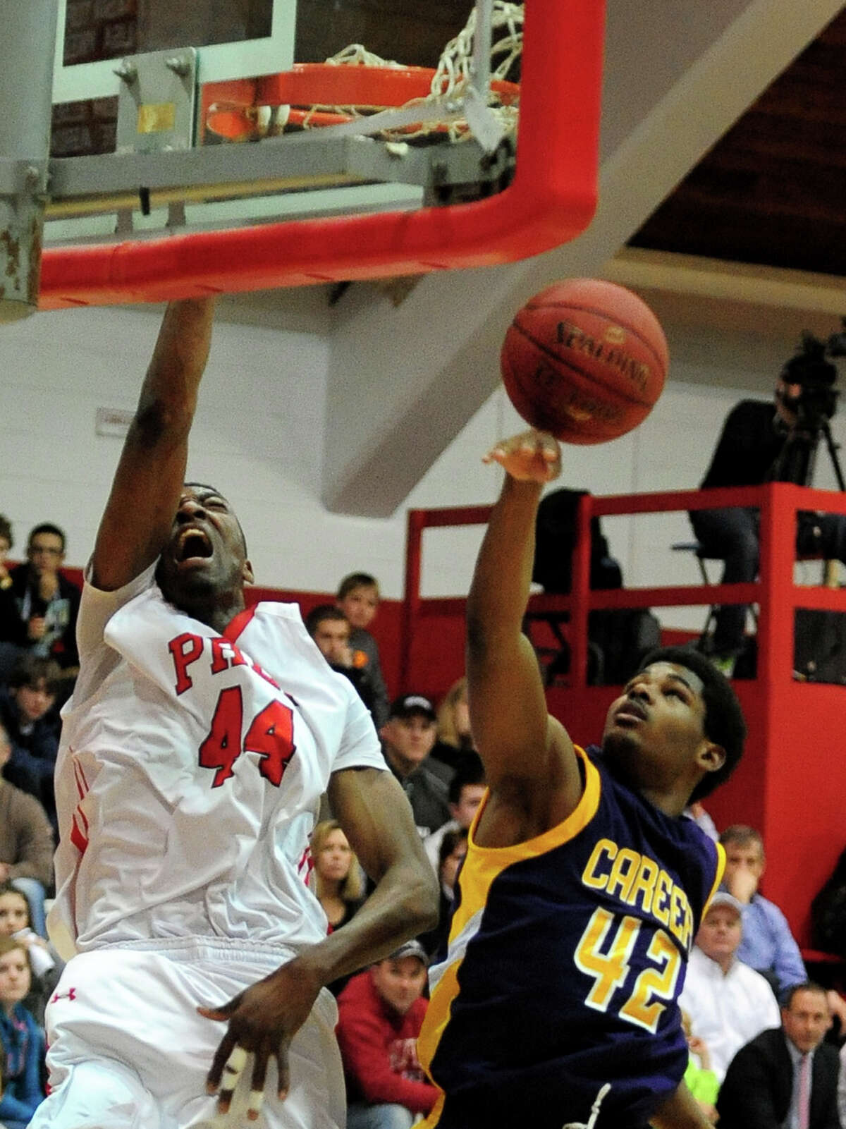 Fairfield Prep's Pascal Chukwa reacts as he slam dunks the ball, during boys basketball action against Career of New Haven in Fairfield, Conn. on Thursday February 20, 2014. At right is Career's Alden Singley.