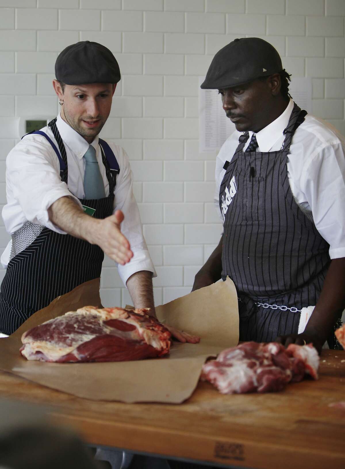 Aaron Rocchino (l to r), co-owner The Local Butcher Shop gives some pointers on wrapping meat to City College of San Francisco student Norman Nesby Jr. as Nesby Jr. works at his internship at The Local Butcher Shop on Thursday, February 20, 2014 in Berkeley, Calif.
