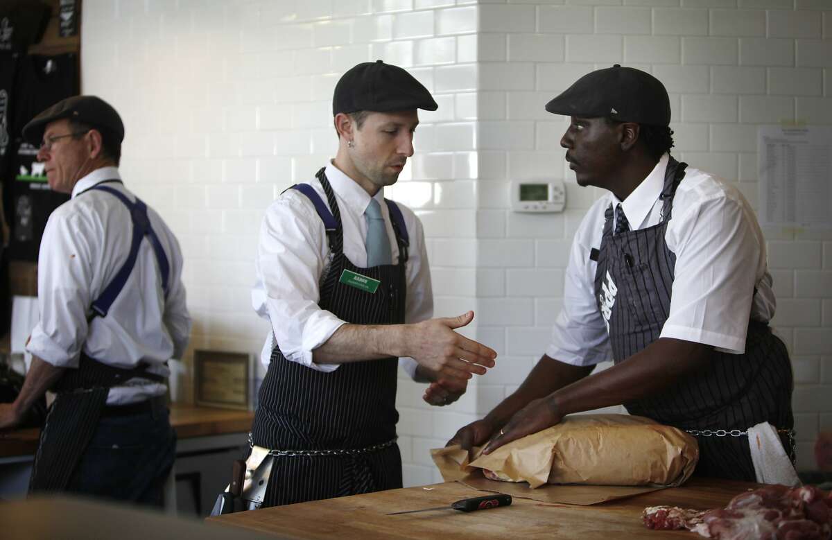 Aaron Rocchino (center), co-owner The Local Butcher Shop gives some pointers on wrapping meat to City College of San Francisco student Norman Nesby Jr. (right) as Nesby Jr. works at his internship at The Local Butcher Shop on Thursday, February 20, 2014 in Berkeley, Calif.