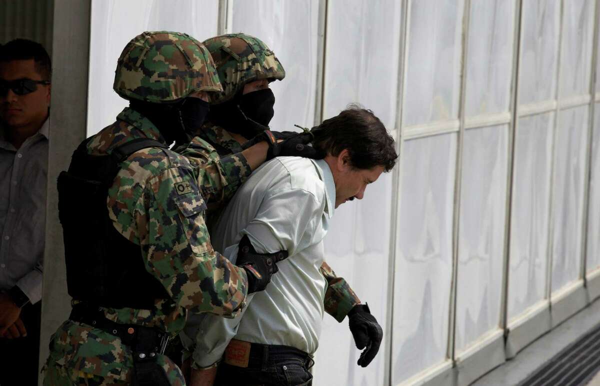 Joaquin "El Chapo" Guzman is escorted to a helicopter in handcuffs by Mexican navy marines at a navy hanger in Mexico City, Saturday, Feb. 22, 2014. A senior U.S. law enforcement official said Saturday, that Guzman, the head of MexicoÃ©­s Sinaloa Cartel, was captured alive overnight in the beach resort town of Mazatlan. Guzman faces multiple federal drug trafficking indictments in the U.S. and is on the Drug Enforcement AdministrationÃ©­s most-wanted list. (AP Photo/Dario Lopez-Mills)