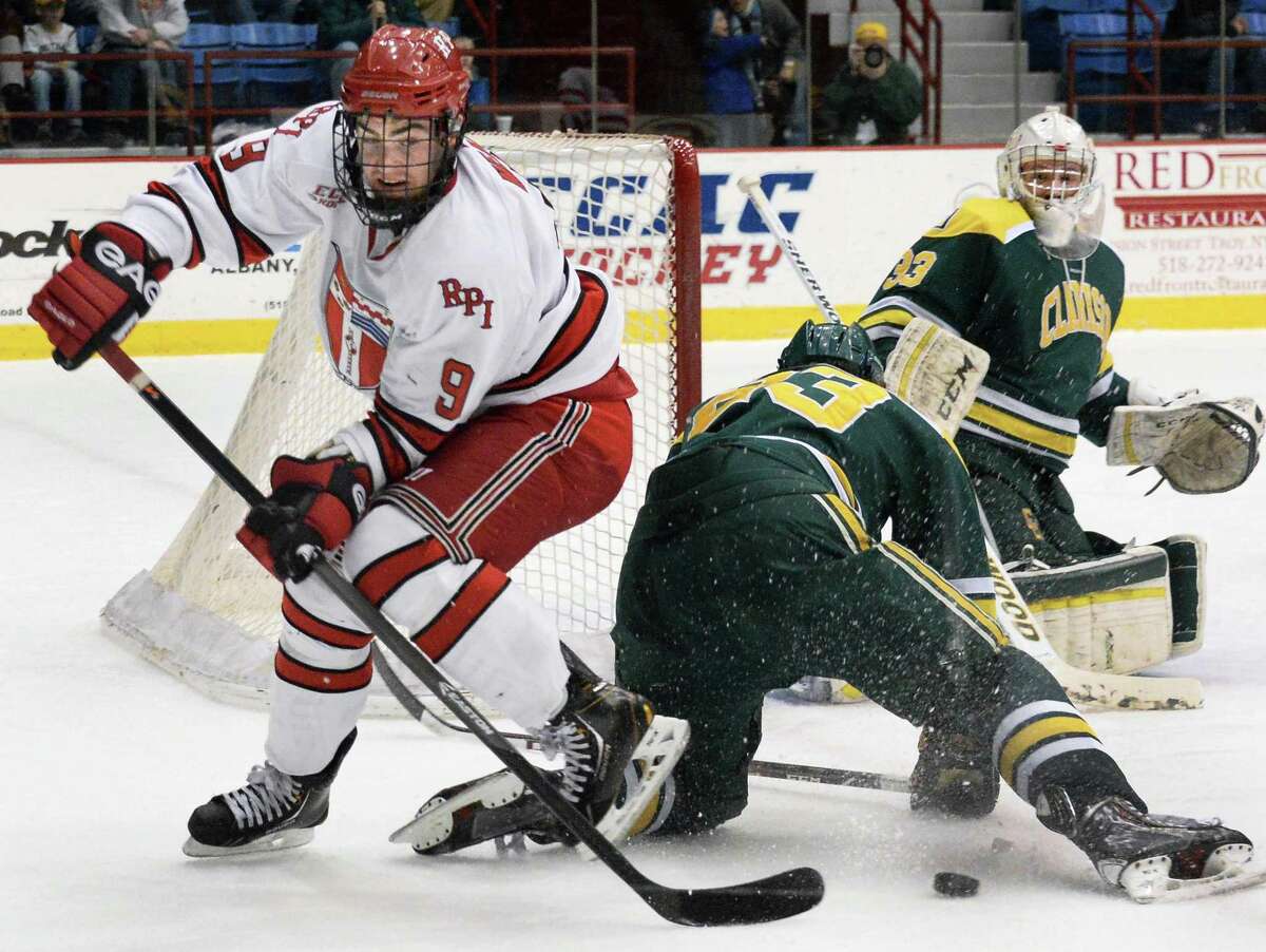 RPI's #9 Matt Neal, left, battles Clarkson's #23, James Howden and goalie Gregg Lewis, at right, during Saturday night's game at the Houston Field House Feb. 22, 2014, in Troy, NY. (John Carl D'Annibale / Times Union)