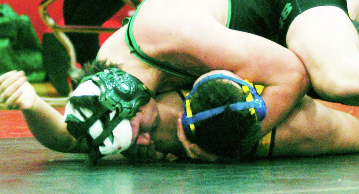Tom McIlveen of the New Miford High School wrestling team scores this clutch pin of Newtown's Ryan Wagner late in the third period of the 220-pound title bout to deliver the Green Wave's eighth straight South-West Conference team championship.