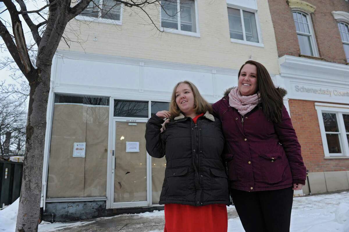 Sara Mae Hickey, right, founder and president of The Autism Initiative, stands with her sister Emily in front of the construction site for Puzzles Bakery & Cafe on State St. on Wednesday, Feb. 19, 2014, in Schenectady, N.Y. The cafe, which will open in the Spring, will be a place for adults with autism to work. Sara Mae's sister is on the autism spectrum. (Lori Van Buren / Times Union)