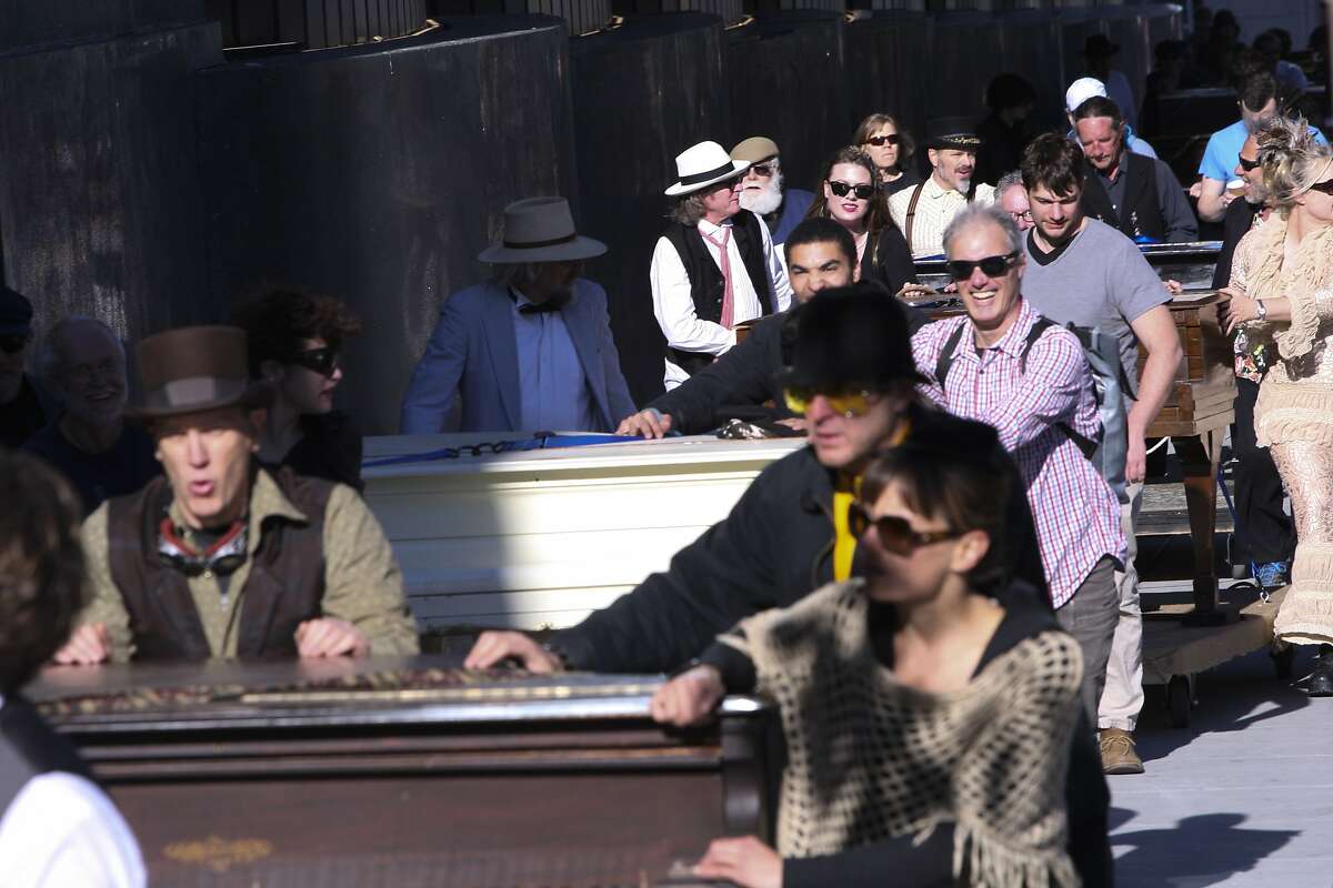 Participants make their way up Howard Street during a procession of pianos that started on the corner of Howard and 6th Street and ended near Mission and 9th streets on Sunday, Feb. 23, 2014 in San Francisco, Calif. Upon arrival, the pianos became part of a carnival-like opening of artist Brian Goggin's new installation, "Caruso's Dream."