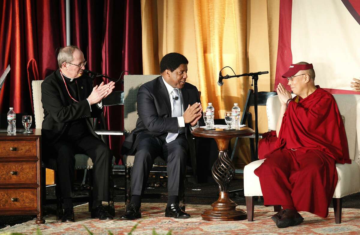 2014年2月24日星期一，在加州圣克拉拉，圣克拉拉大学利维活动中心，尊严健康公司总裁兼首席执行官Lloyd Dean(中)和圣克拉拉大学校长Rev. Michael Engh(左)在“商业、伦理和同情:与达赖喇嘛的对话”结束时相互鞠躬。