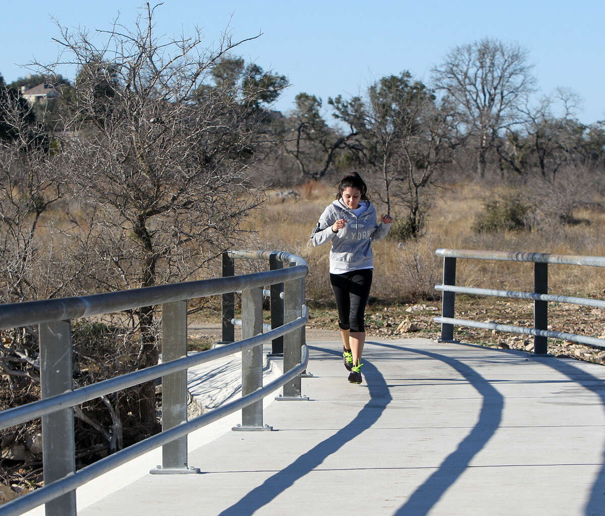 Cristal Cristia jogs across a bridge at Stone Oak Park, 20395 Stone Oak Parkway, a haven for residents and wildlife on the North Side,