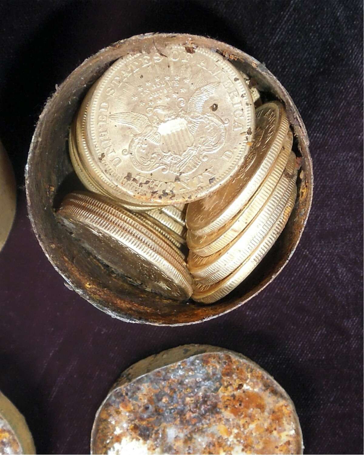 This image provided by the Saddle Ridge Hoard discoverers via Kagin's, Inc., shows one of the six decaying metal canisters filled with 1800s-era U.S. gold coins unearthed in California by two people who want to remain anonymous. The value of the "Saddle Ridge Hoard" treasure trove is estimated at $10 million or more. (AP Photo/Saddle Ridge Hoard discoverers via Kagin's, Inc.)
