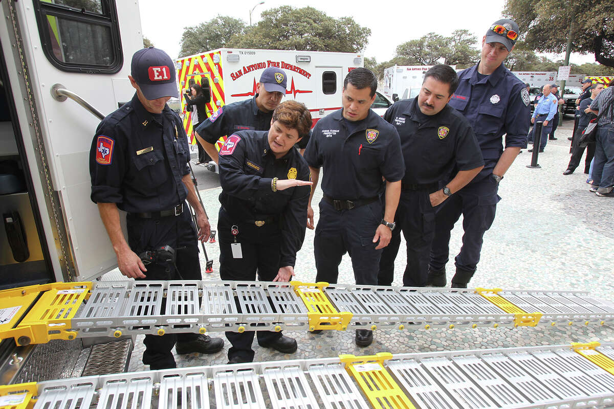 EMS Chief Yvette Granato explains the workings of new style ramps as the SAFD unveils its new fleet of ambulances by rolling out 16 of the units at SAPD headquarters on February 25, 2014.