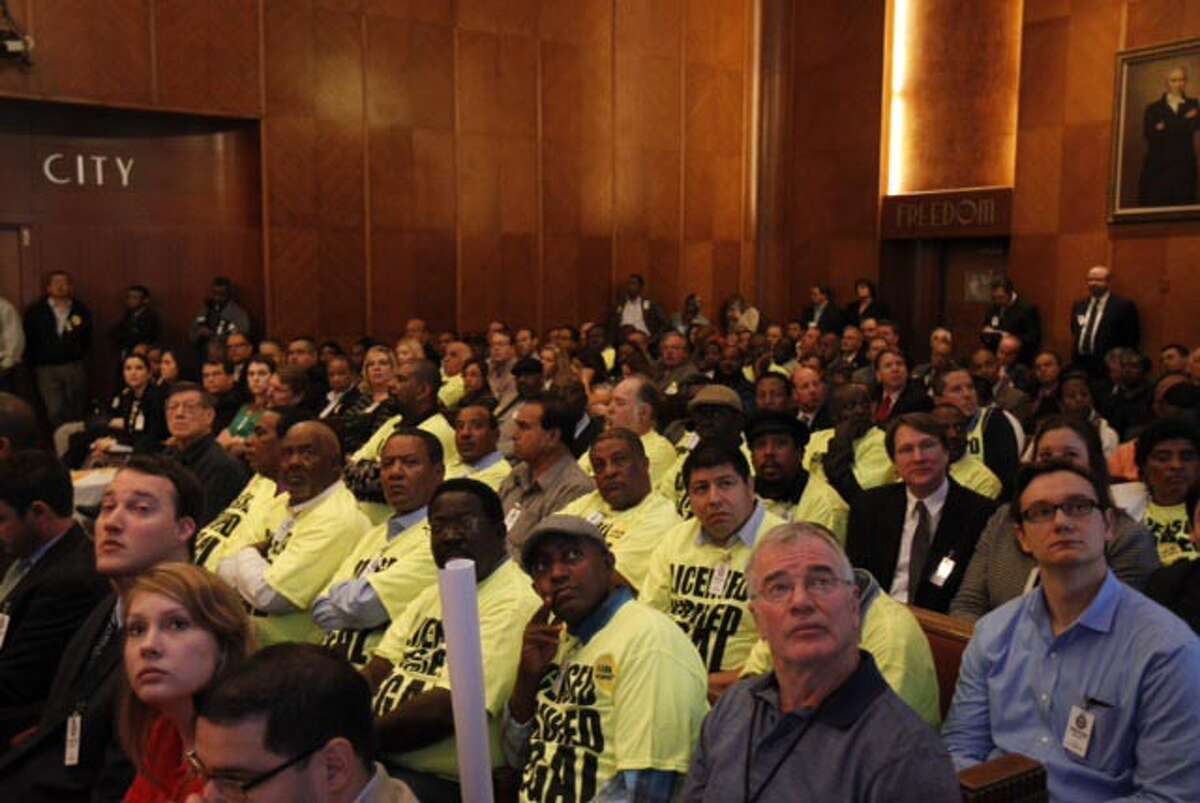 Houston Yellow Cab drivers attend Houston mayor's meeting at City Hall, Tuesday, Feb. 25, 2014, wearing yellow T-shirts to protest the Uber company. Uber allows anyone to request a ride via mobile app, text message or the web.