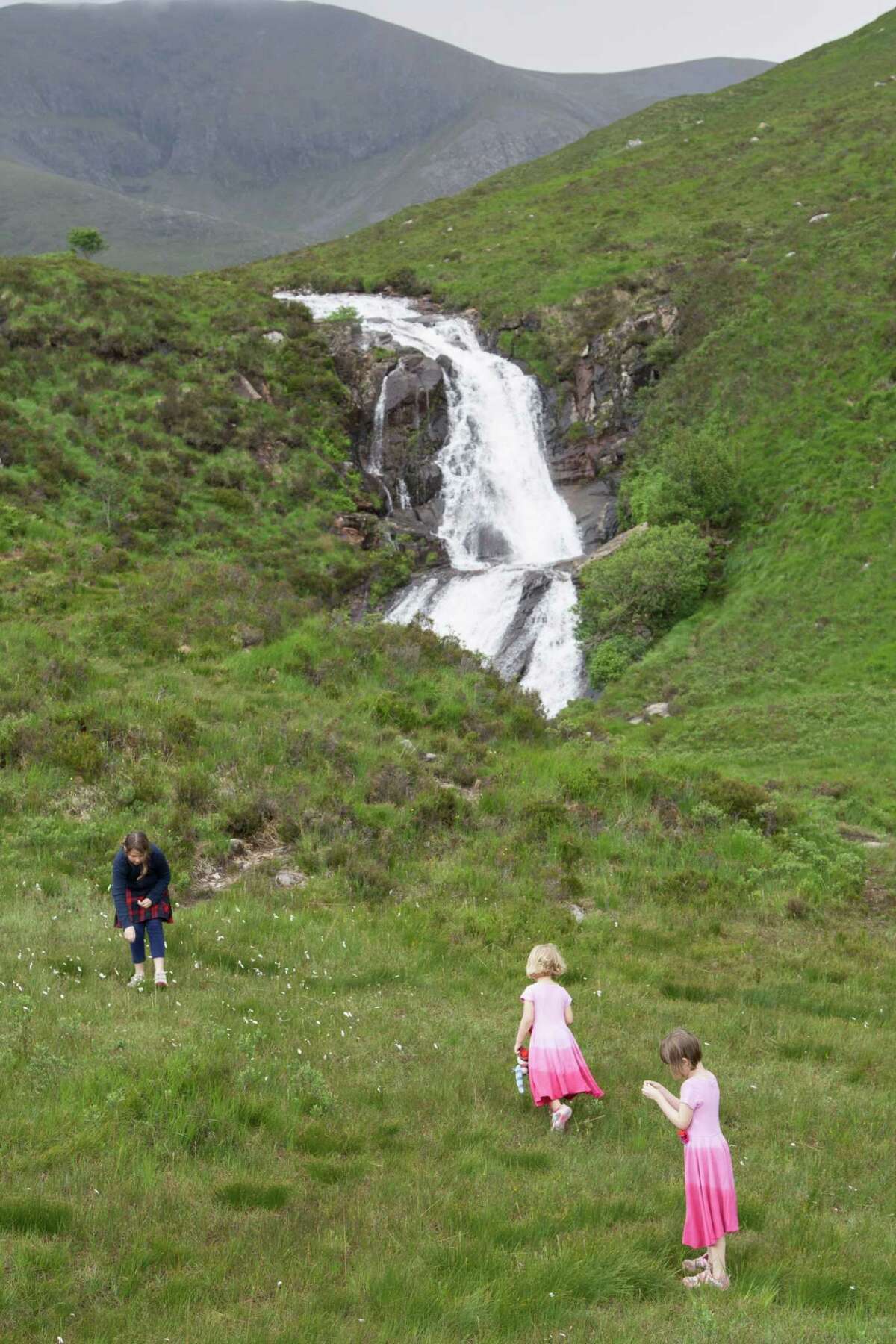 Right: Children enjoy a roadside waterfall on the Isle of Skye.