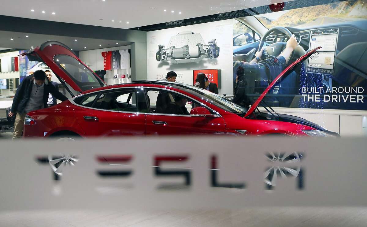 A man looks around Tesla Motors' Model S P85 at its showroom in Beijing in this January 29, 2014 file photo. Panasonic Corp is considering investing in a U.S. car battery plant planned by Tesla Motors Inc, sources familiar with the plan said on February 26, 2014, with total investment estimated by one source around 100 billion yen ($979 million). REUTERS/Kim Kyung-Hoon/Files (CHINA - Tags: BUSINESS TRANSPORT)