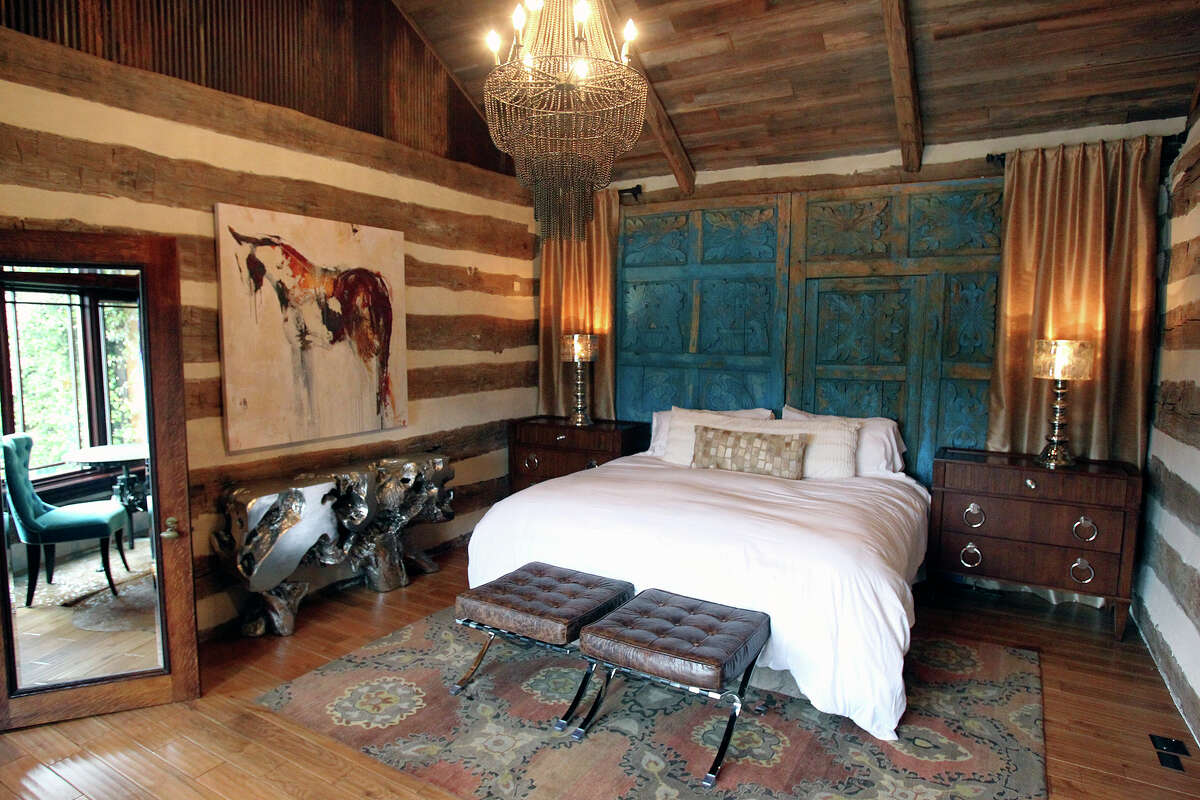 Antique doors from a church serve as a headboard of a bed in the home of Bex and David Hale in Wimberley.