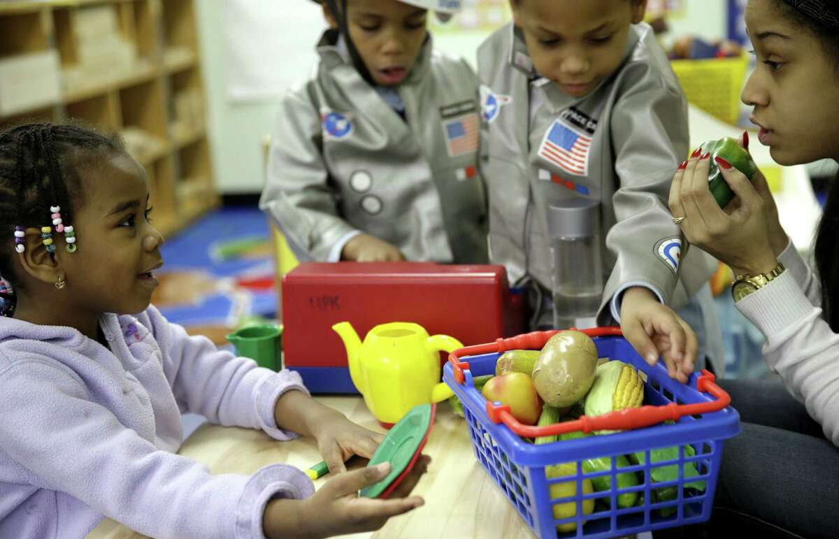 Oumou Balde (left) plays with her teacher Jacqualine Sanchez and some pretend food in a New York prekindergarten class designed to educate kids about nutrition and health.