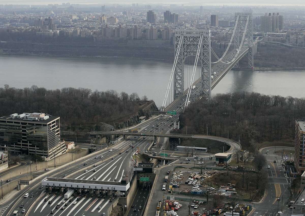 In this Dec. 1, 2013 file aerial photo, the tollbooth lanes, lower left, lead to the George Washington Bridge in Fort Lee, N.J. Many people have known little about Fort Lee until a political scandal centering on New Jersey Gov. Chris Christie enveloped the borough. Now for residents of the New York City bedroom community defined by both a feisty pride and frustration over the mixed blessings of proximity to the George Washington Bridge, the scandal is the reminder they did not need of how the bridge dictates the rhythm of everyday life. (AP Photo/Mark Lennihan, File)