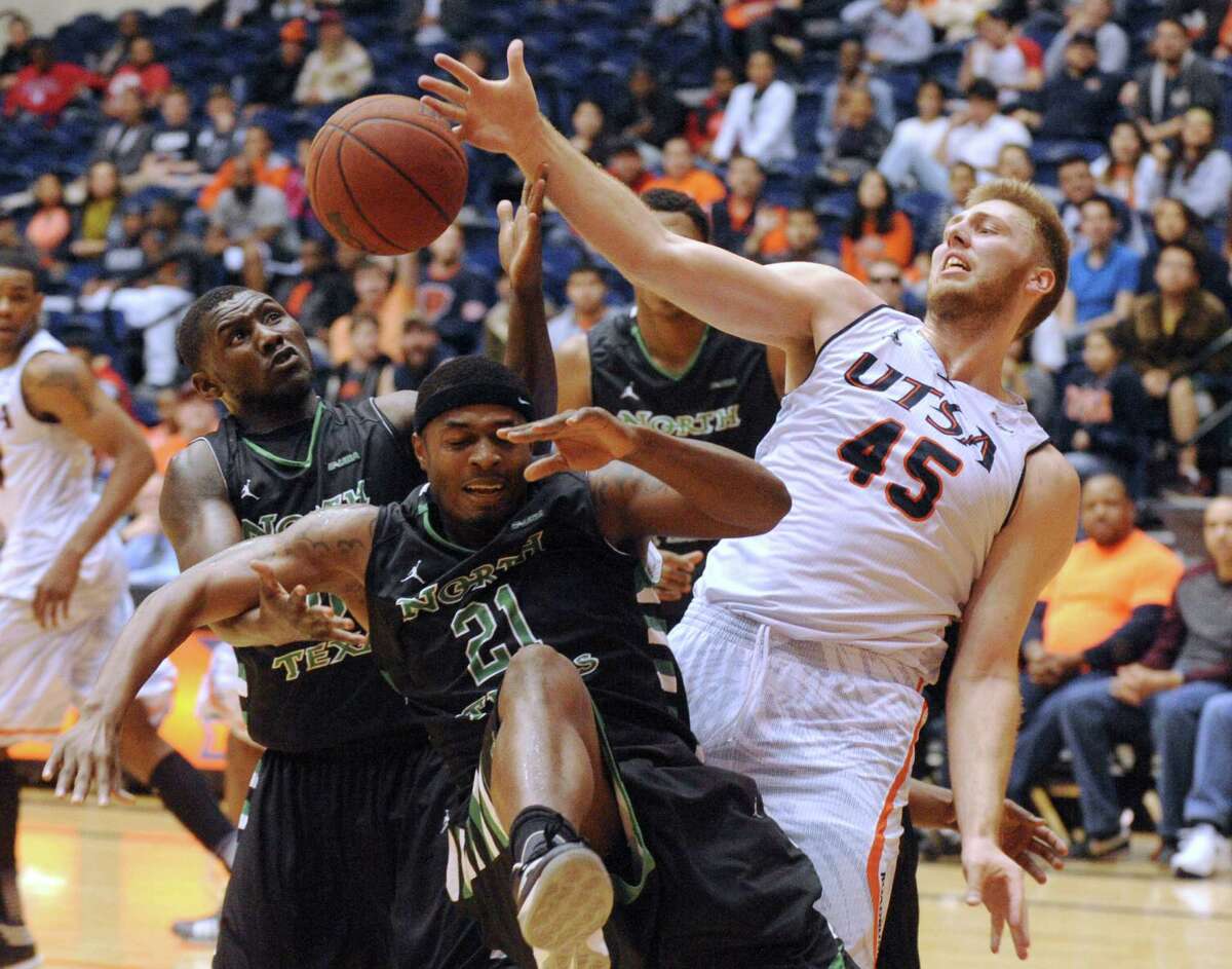 Kaj-Björn Sherman of UTSA, right, battles for a loose ball against T. J. Taylor (21) and Vertrall Vaughns of North Texas during college basketball action at the UTSA Convocation Center on Thursday, Feb. 27, 2014.