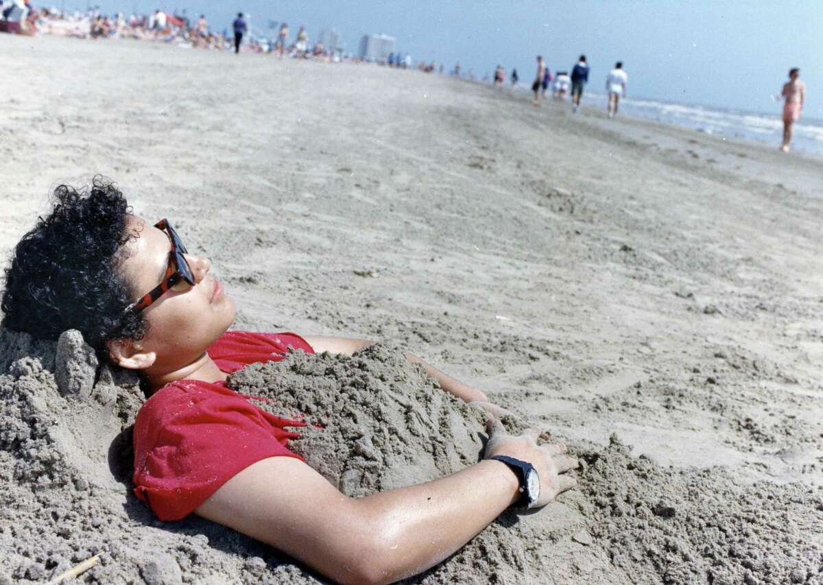 Spring breaker Ana Orellana of Houston found the Galveston sand to be just the right cover-up for today s bright skies. Near Stewart Beach. March 14, 1992