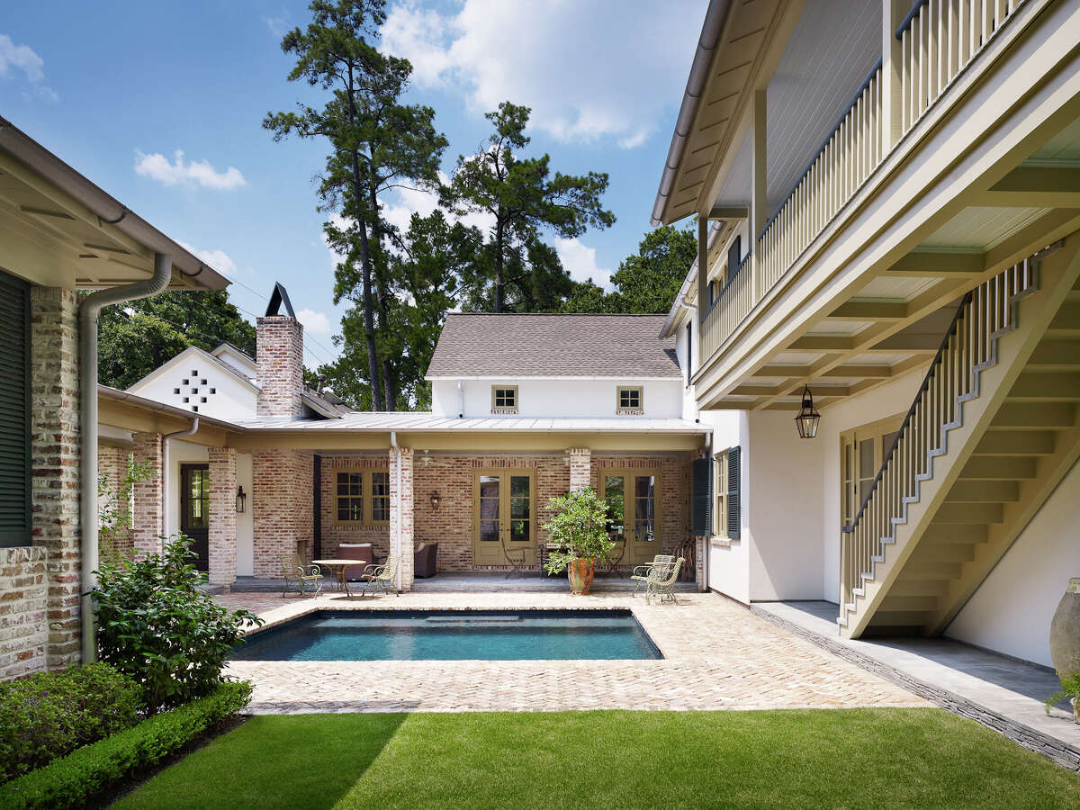 Chicago brick decking, laid in a herringbone pattern, surrounds the square pool in the courtyard.