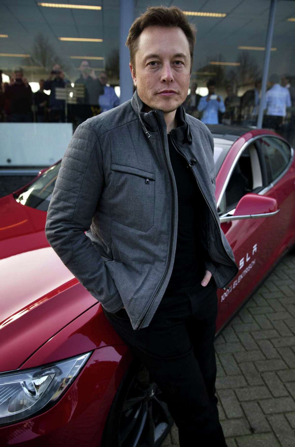 Elon Musk, co-founder and CEO of American electric vehicle manufacturer Tesla Motors, poses with a Tesla during a visit to Amsterdam on January 31, 2014. The European Tesla Service is based in Tilburg and the European headquarters is in Amsterdam. AFP PHOTO / ANP/ JERRY LAMPEN --NETHERLANDS OUT--JERRY LAMPEN/AFP/Getty Images