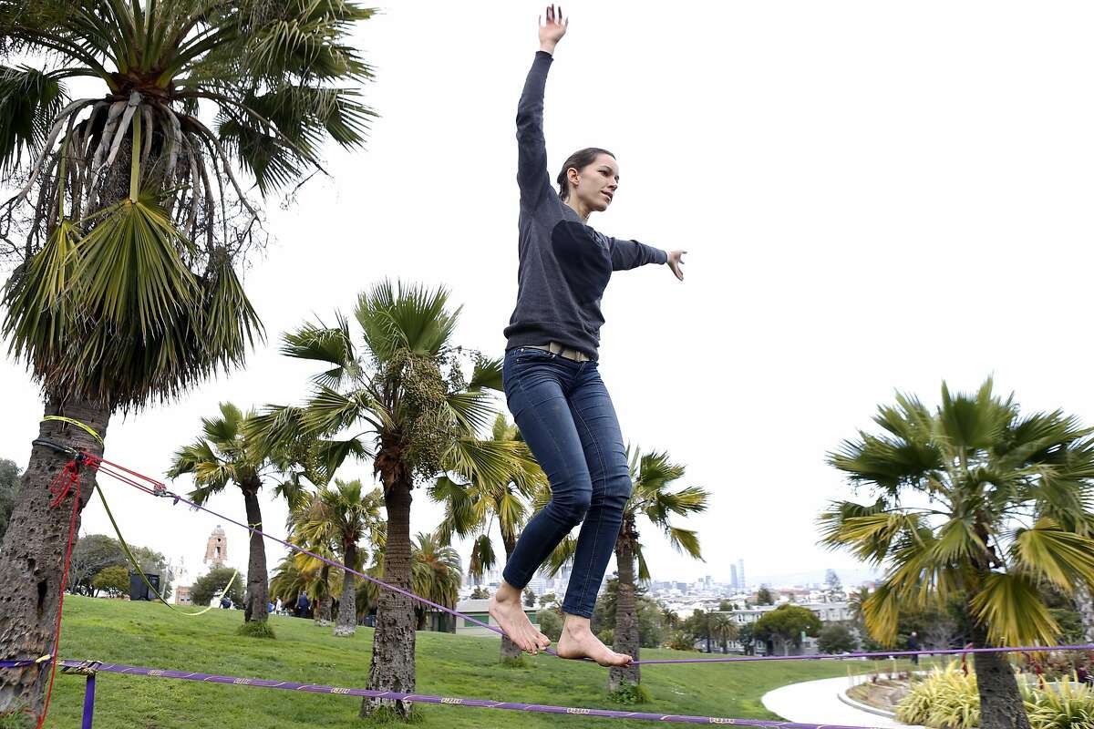 Lauren Crepeau walks a slack line at Dolores Park in San Francisco, Calif., on Thursday, February 27, 2014. Dolores Park, one of the most popular spots in the city, is closing Saturday for more than a year of rehab work and upgrades.