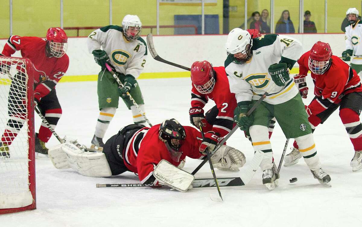 Trinity Catholic's Will Egan is surrounded by Greenwich defenders as he tries to regain control of the puck near the net during Saturday's FCIAC quarterfinal at Terry Conners Rink in Stamford, Conn., on March 1, 2014.