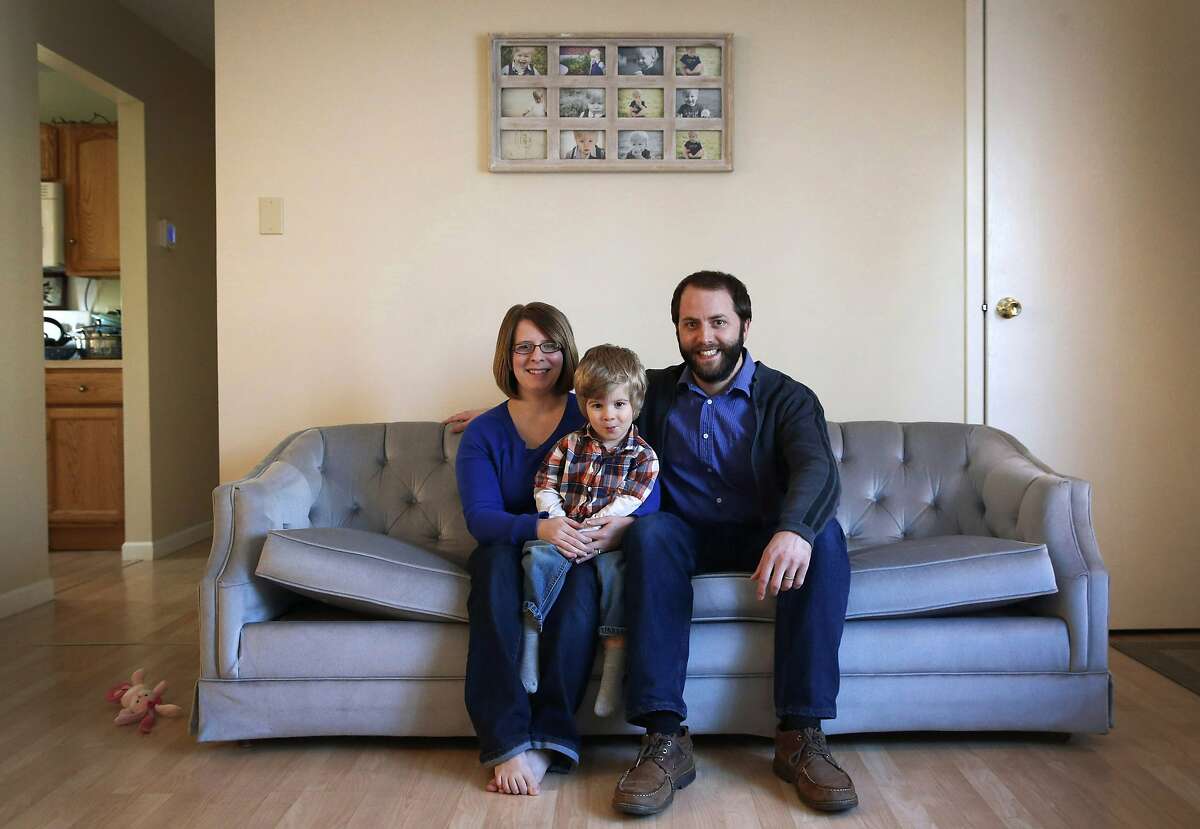 In this Feb. 26, 2014 photo, Jacki and David Manley pose with their son Tyndale, age 2, in their home in Keedysville, Md. Jacki Manley has been trying since mid-December to enroll in a health plan through Maryland's health exchange. With a child who is almost 3 and another who is 5 months, the 20 minutes the stay-at-home mom can spare on hold have not been enough. She estimates she has reached someone at the Maryland call center three out of about a dozen times she has called, but then she gets passed between different people and cannot get definitive answers to her questions. (AP Photo/Patrick Semansky)