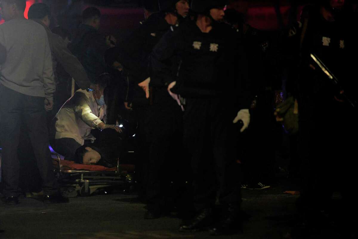 The body of a victim is inspected by police officers outside a railway station, after an attack in Kunming, in southwestern China's Yunnan province, Saturday March 1, 2014. China's official Xinhua News Agency says authorities consider the attack by a group of knife-wielding assailants at a train station in southwestern China in which at least 27 people died to be an act of terrorism. (AP Photo) CHINA OUT