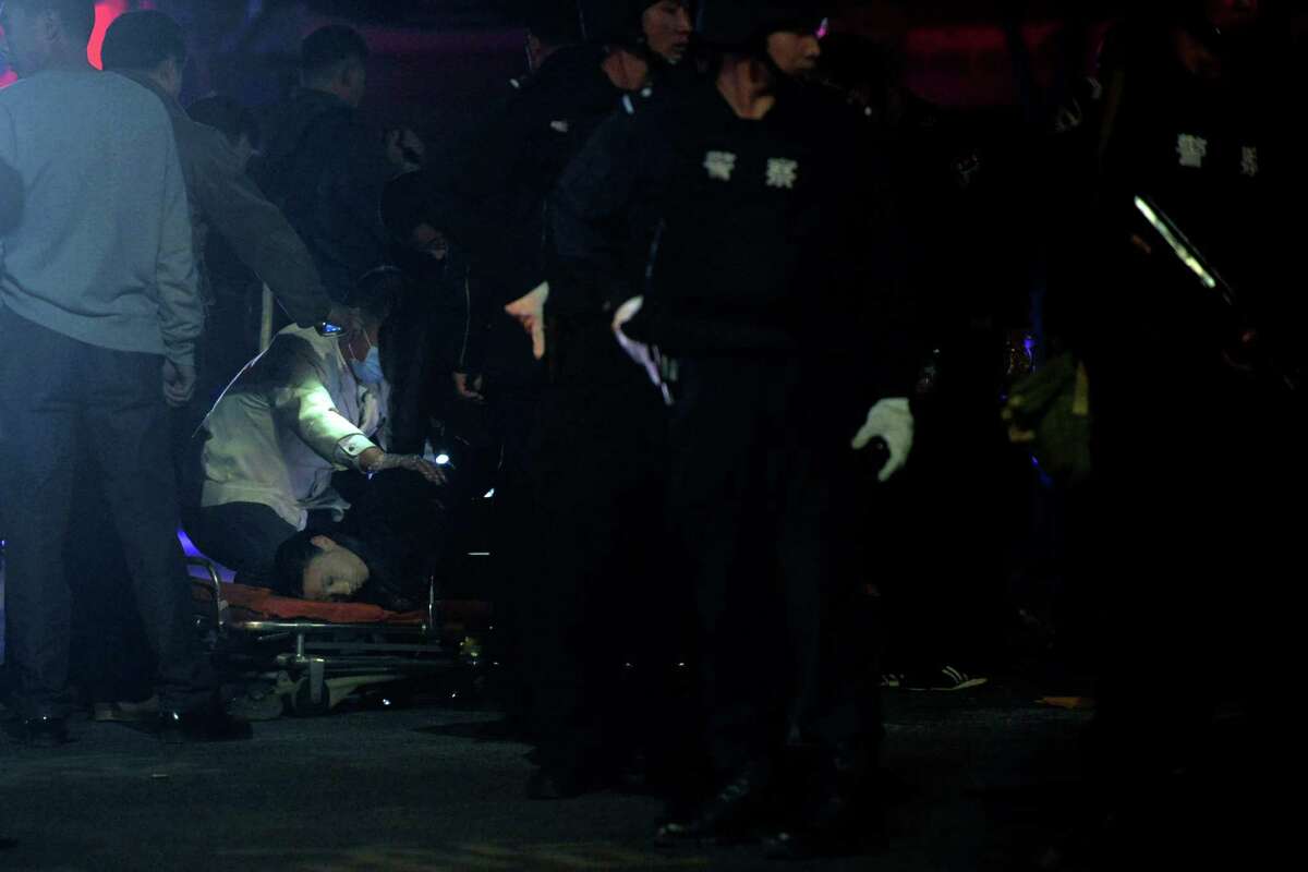 The body of a victim is inspected by police officers outside a railway station, after an attack in Kunming, in southwestern China's Yunnan province, Saturday March 1, 2014. China's official Xinhua News Agency says authorities consider the attack by a group of knife-wielding assailants at a train station in southwestern China in which at least 27 people died to be an act of terrorism. (AP Photo) CHINA OUT
