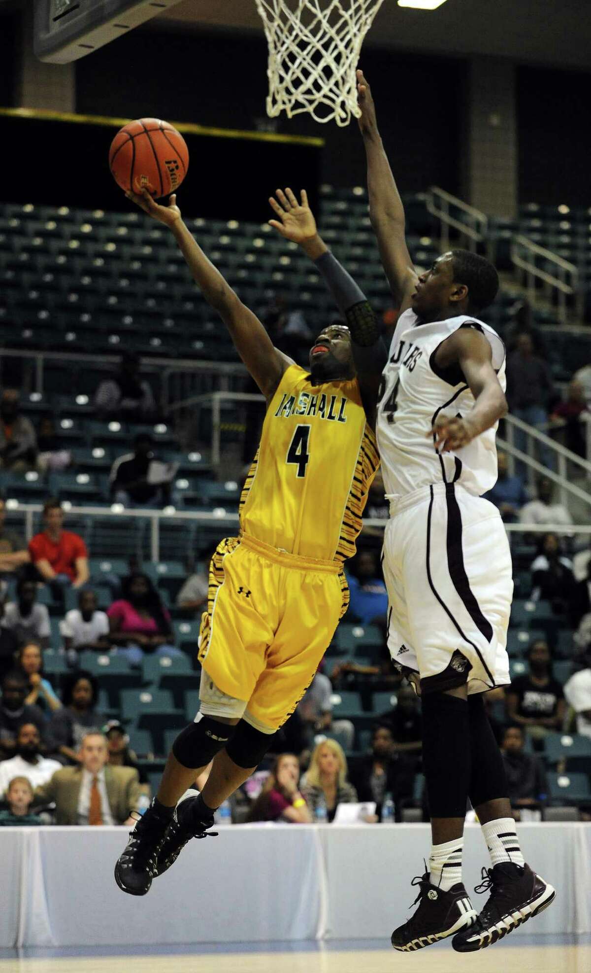 Fort Bend Marshall's D.J. Day, left, gets the inside track to the basket as Beaumont Central's John Walker defends Saturday at the Merrell Center.