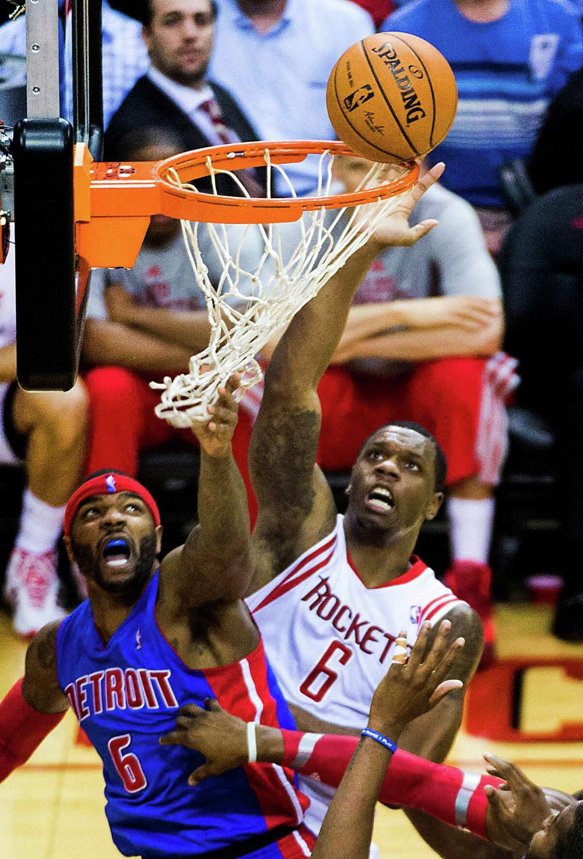 The ball hangs on the rim as Rockets forward Terrence Jones goes up for a tip against Pistons forward Josh Smith, who is nearly entangled in the net.