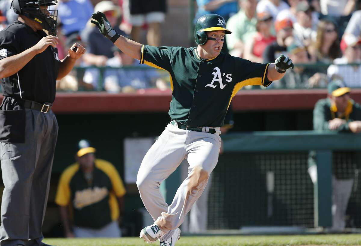 A's Nick Punto, (1) scores a run on a Brandon Moss, (37) single in the 4th inning, as the Oakland Athletics went on to beat the San Francisco Giants 10-5 in a spring training game at Scottsdale Stadium, in Scottsdale, Arizona on Wednesday Feb. 26, 2014.