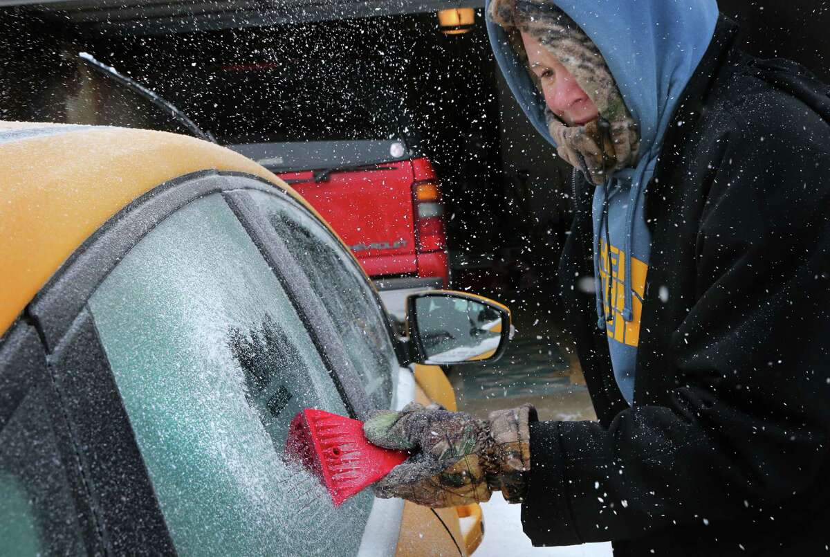 Landon Porter, 15, scrapes the ice off his mother's car outside his home Sunday, March 2, 2014, in St. Charles, Mo. A winter storm packing high winds, ice and heavy snow threatened to create hazardous driving conditions across Kansas and Missouri, accompanied by wind chills approaching 25 below zero in some areas. (AP Photo/St. Louis Post-Dispatch, David Carson)
