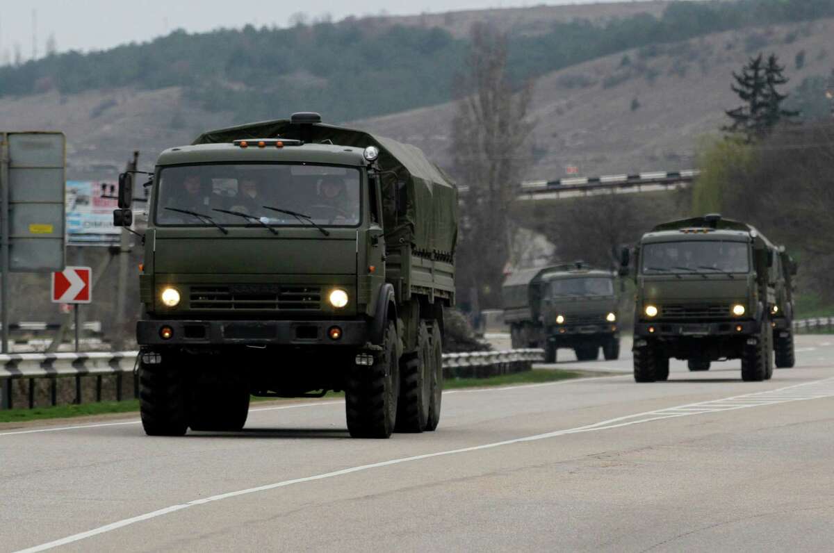 A Russian convoy moves from Sevastopol to Sinferopol in the Crimea, Ukraine, Sunday, March 2, 2014. A convoy of hundreds of Russian troops headed toward the regional capital of Ukraine's Crimea region on Sunday, a day after Russia's forces took over the strategic Black Sea peninsula without firing a shot. The new government in Kiev has been powerless to react. Ukraine's parliament was meeting Sunday in a closed session. (AP Photo/Darko Vojinovic)