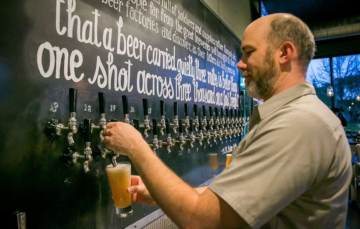 John Hill pours a beer at Hogsapothecary in Oakland, Calif., is seen on Wednesday, February 26th, 2014.