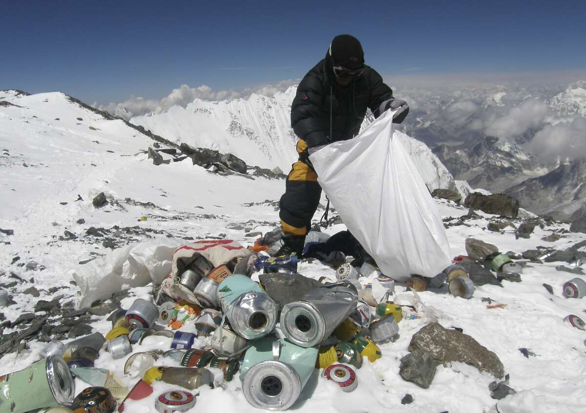 (FILES) This picture taken on May 23, 2010 shows a Nepalese sherpa collecting garbage, left by climbers, at an altitude of 8,000 metres during the Everest clean-up expedition at Mount Everest. Climbers scaling Mount Everest will have to bring back eight kilograms (17.6 pounds) of garbage under new rules designed to clean up the world's highest peak, a Nepalese official said March 3, 2014. AFP PHOTO/Namgyal SHERPA/FILESNAMGYAL SHERPA/AFP/Getty Images