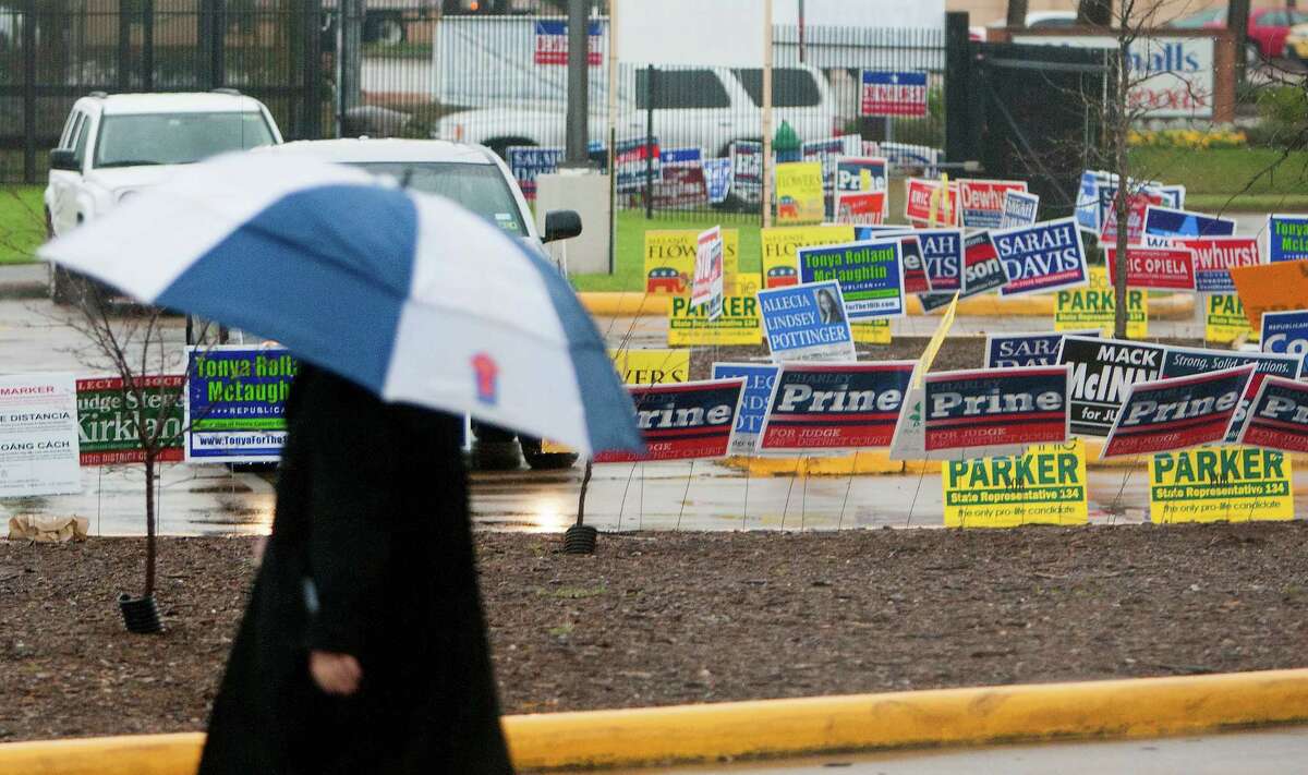 Rain falls as a voter makes his way from the Metropolitan Multi-Services Center as the doors open to voters, Tuesday, March 4, 2014, in Houston. (AP Photo/Houston Chronicle, Cody Duty)