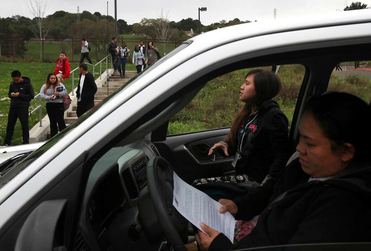 Hershey Monzon, right, reads a flier about an alleged sexual assault from her daughter Hazel Monzon, 18, as Hazel gets in the car after school March 4, 2014 at Hercules Middle High School in Hercules, Calif. A 15-year-old transgender student who identifies as male reported being sexually assaulted in the handicap stall of a men's bathroom yesterday at 11:00am. Hershey says that Hazel has dealt with bullying before and does not always feel safe at school.