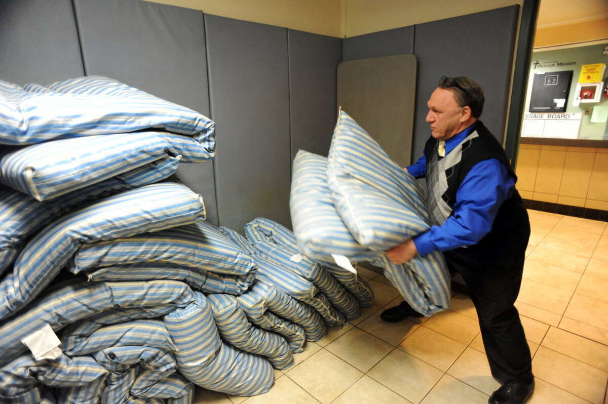 Perry Jones, executive director of Capital City Rescue Mission on South Pearl Street, moves mattresses for Code Blue clients on a cold night in January. (Times Union archive)