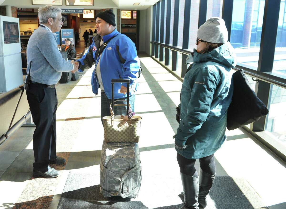 Wounded Warrior Sgt. Gonzolo Duran is greeted by Rensselaer's Amtrak assistant station manager, left, as he arrives at the Rensselaer Train Station on Thursday March 6, 2014 in Rensselaer, N.Y. Duran's fiancee, Rosa Perelta, is traveling with him. (Lori Van Buren / Times Union)