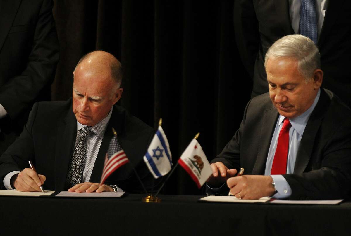 Israeli Prime Minister Benjamin Netanyahu, right, signs an agreement with Gov. Edmund G. Brown Jr. during a public meeting between the two leaders to sign an agreement that expands California's partnership with Israel on trade, research and economic development March 5, 2014 at the Computer History Museum in Mountain View, Calif.