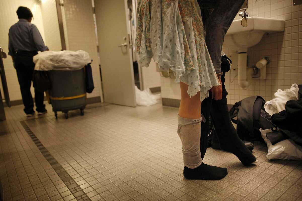 Molly, who is currently homeless, changes her clothes in a San Francisco Main Library restroom on Thursday, March 6, 2014, in San Francisco, Calif.