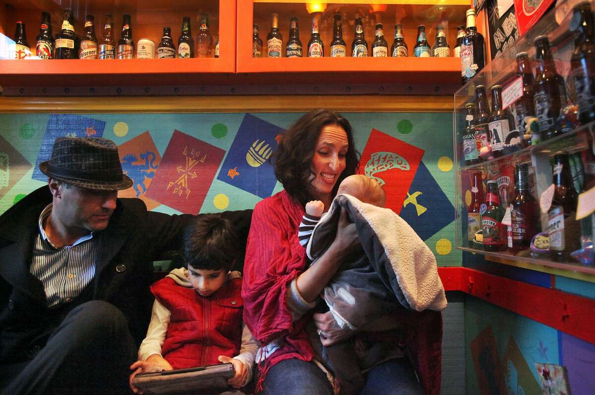 Rino and Sandra Benenati wait for their table to be called with their children, Adrian, 6, left, and Gabriel 4 months, at El Toreador March 7, 2014 on West Portal Ave. in San Francisco, Calif. The couple live nearby and say they come to the restaurant often and enjoy the neighborhood because it's walkable and family oriented.