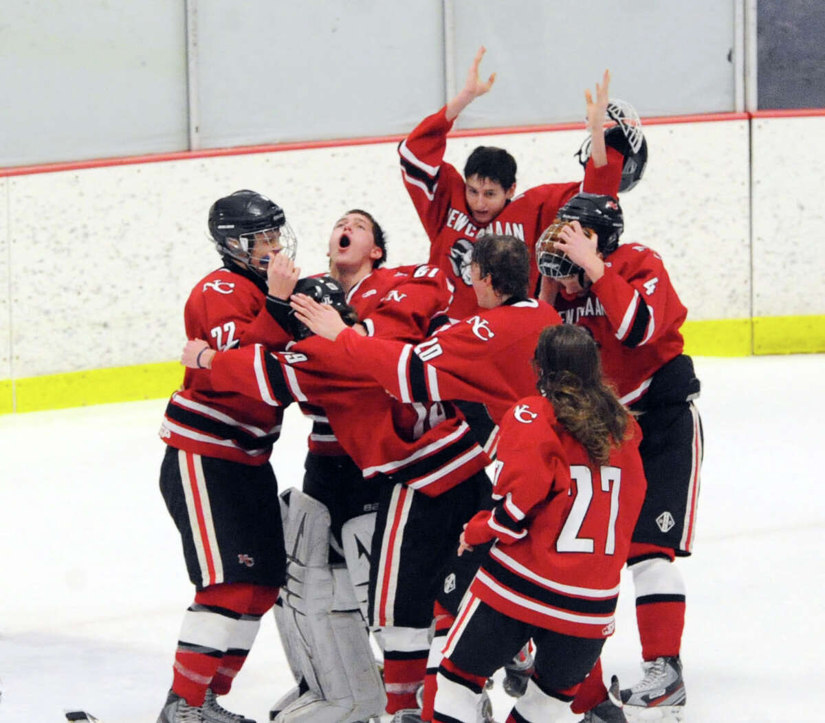 New Canaan goalie MacLean Wright, second from left, screams as he is surrounded by teammates at the conclusion of a 5-2 victory over Darien as New Canaan won the FCIAC boys hockey championship game at Terry Conners Rink in Stamford, Saturday, March 8, 2014. New Canaan players are Pat Hompe (#22), left, James Franzis (#20) and Cooper Manchuck (#27), bottom right. Wright was named the MVP.