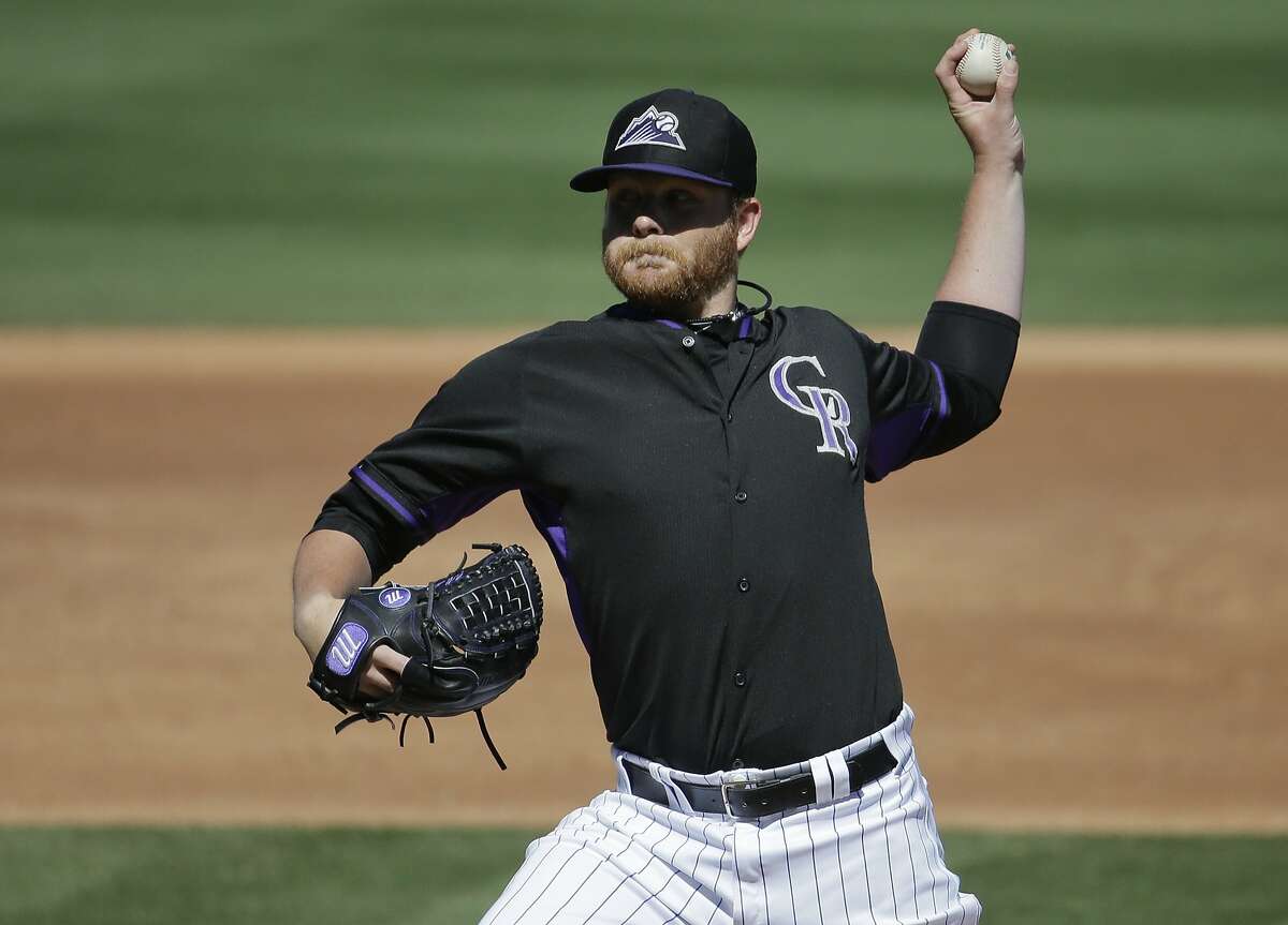Colorado Rockies starting pitcher Brett Anderson throws against the Oakland Athletics during the second inning of a spring training baseball game in Scottsdale, Ariz., Saturday, March 8, 2014. (AP Photo/Chris Carlson)