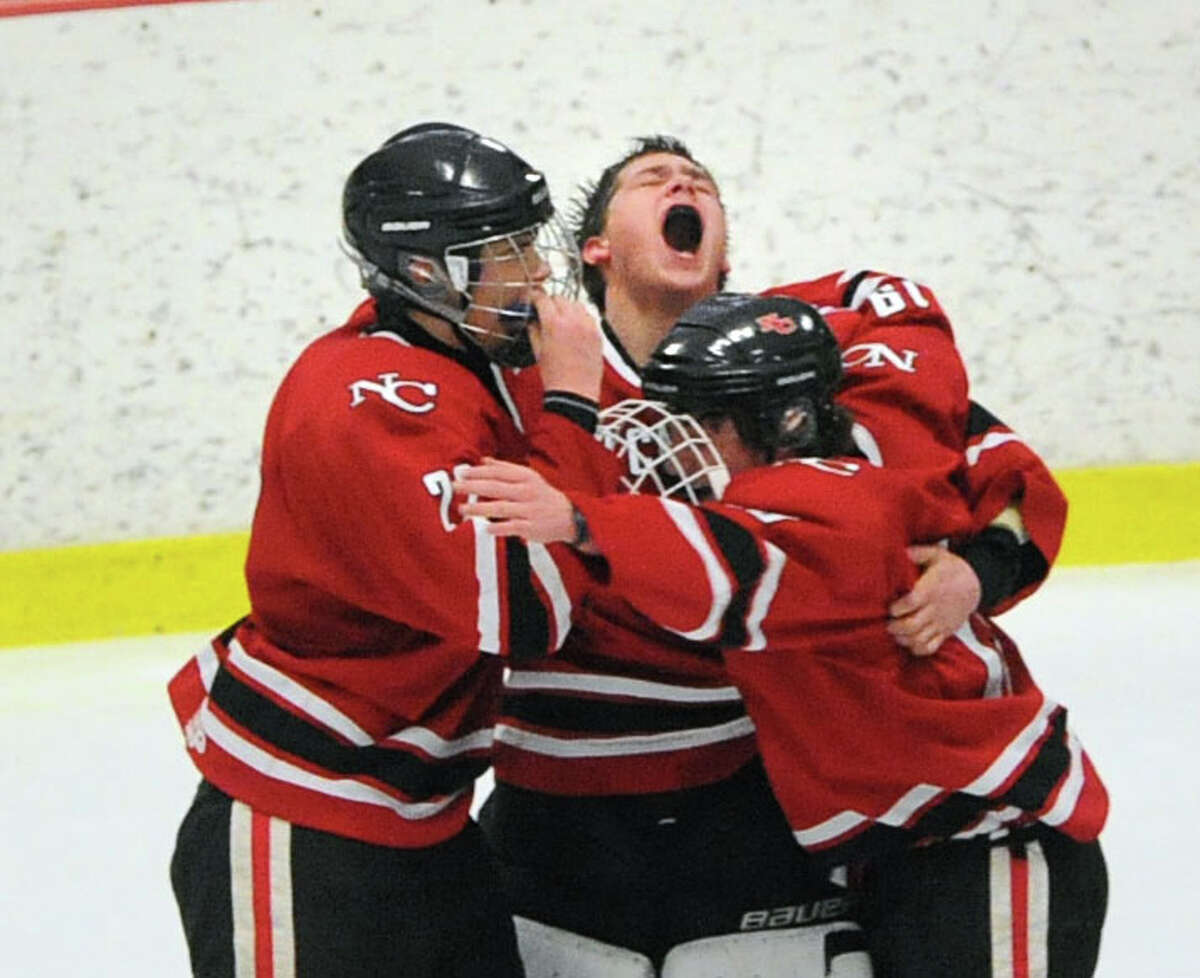 New Canaan goalie MacLean Wright, center, screams as he is surrounded by teammates at the conclusion of a 5-2 victory over Darien as New Canaan won the FCIAC boys hockey championship game at Terry Conners Rink in Stamford, Saturday, March 8, 2014.Wright was named the MVP.